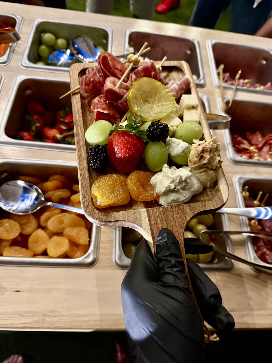 A finished personal charcuterie board held over the cart