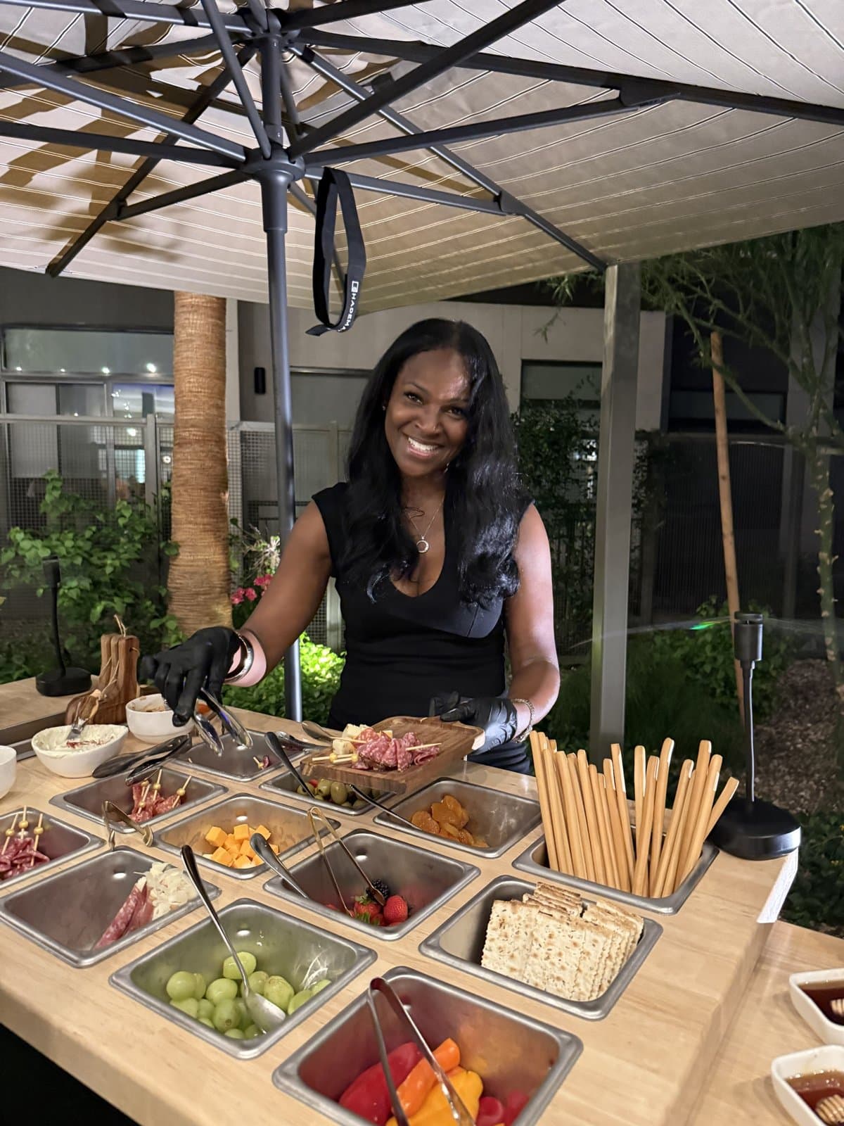 LaVonda building a charcuterie board at the Boards and Bubbly cart